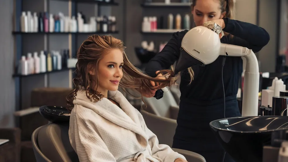 kaderník aplikuje hair gloss na farbené vlasy