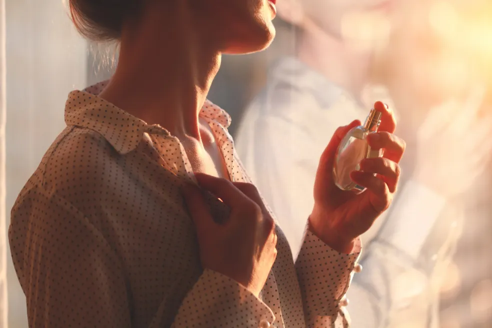 žena si nanáša parfum na krk počas každodennej beauty rutiny