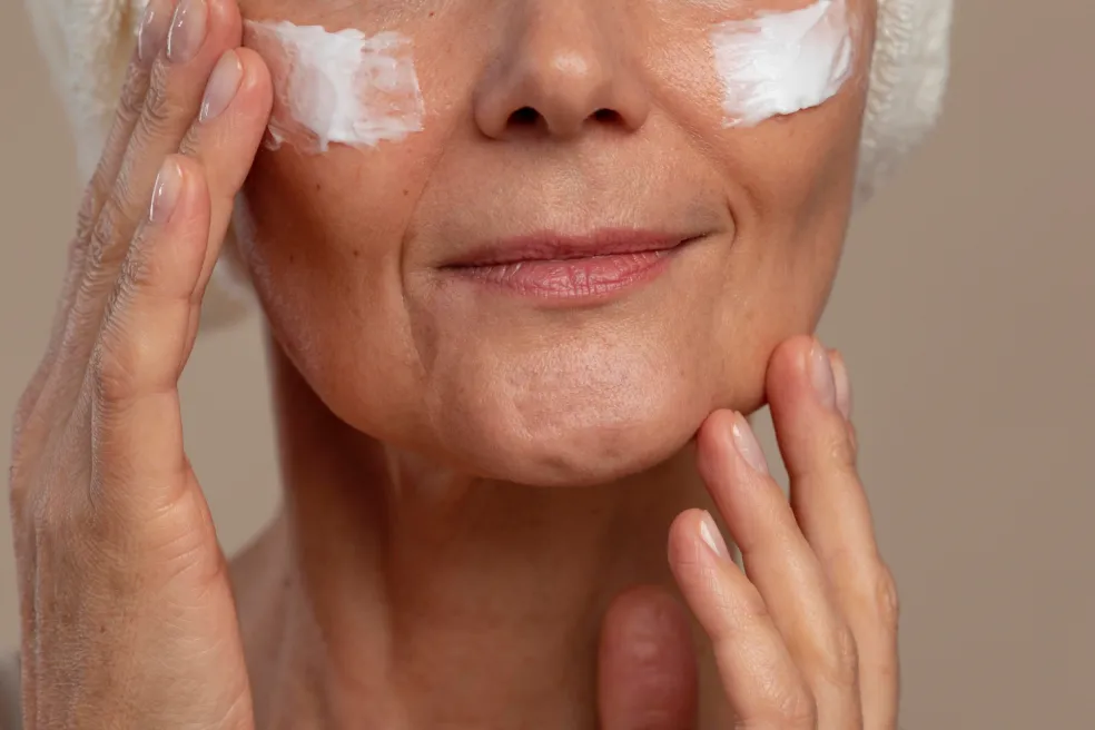 žena aplikuje SPF na tvár ako ochranu kolagénu pred UV žiarením