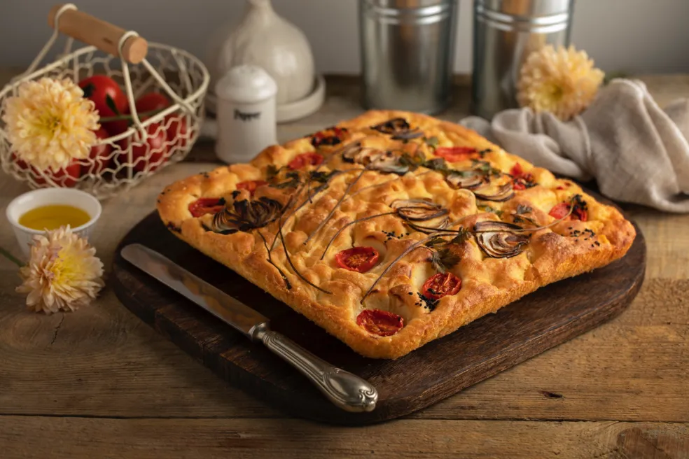 upečená focaccia so zlatistým povrchom a chrumkavými okrajmi