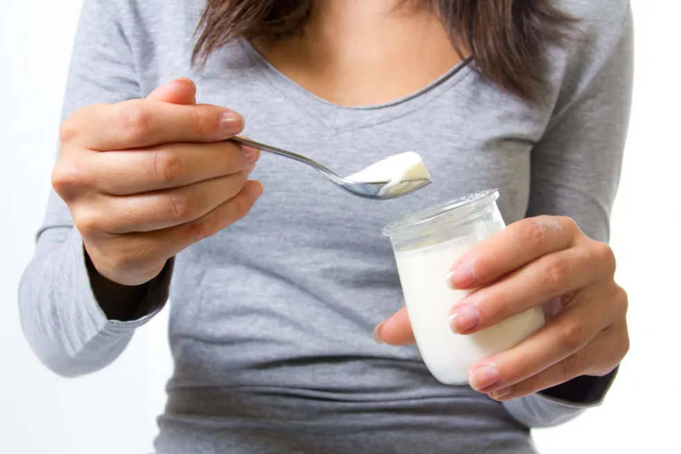 Žena drží biely jogurt – domáce rady na biele škvrny po opaľovaní nemajú univerzálny účinok
