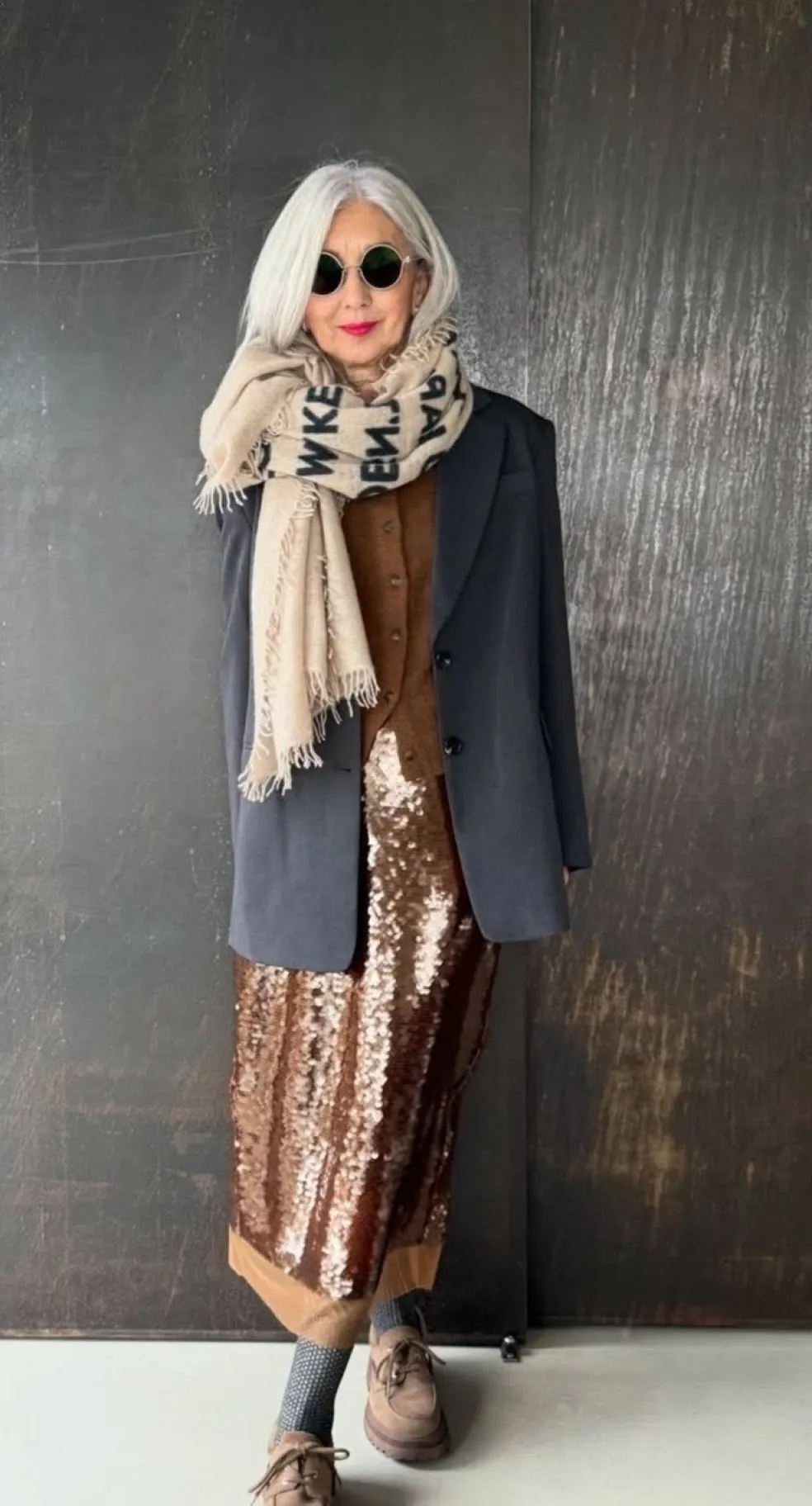 Štýlová žena nad 50 v elegantnom outfite s výraznými módnymi doplnkami