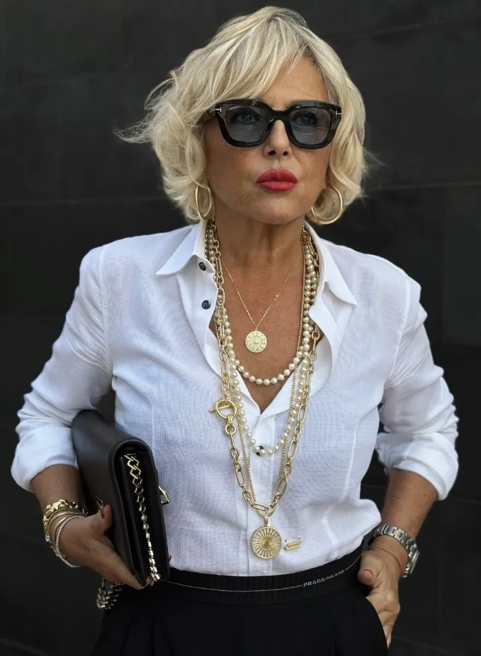 Žena s výrazným náhrdelníkom a jednoduchým elegantným oblečením