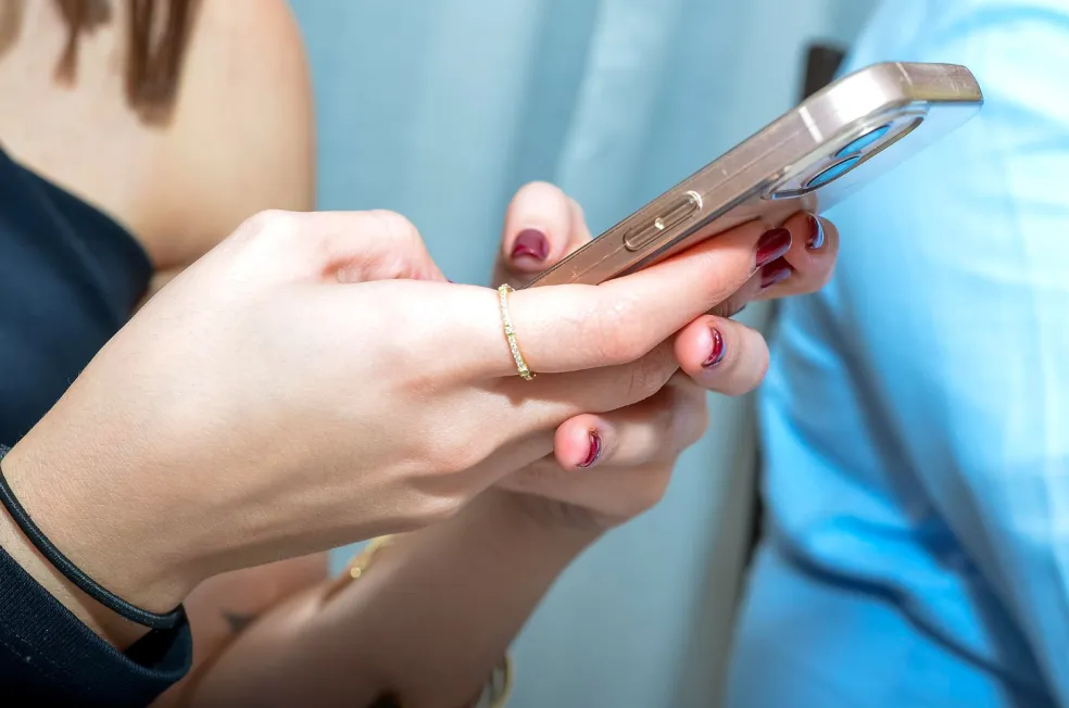 Žena používa smartfón a píše správu palcom na ruke