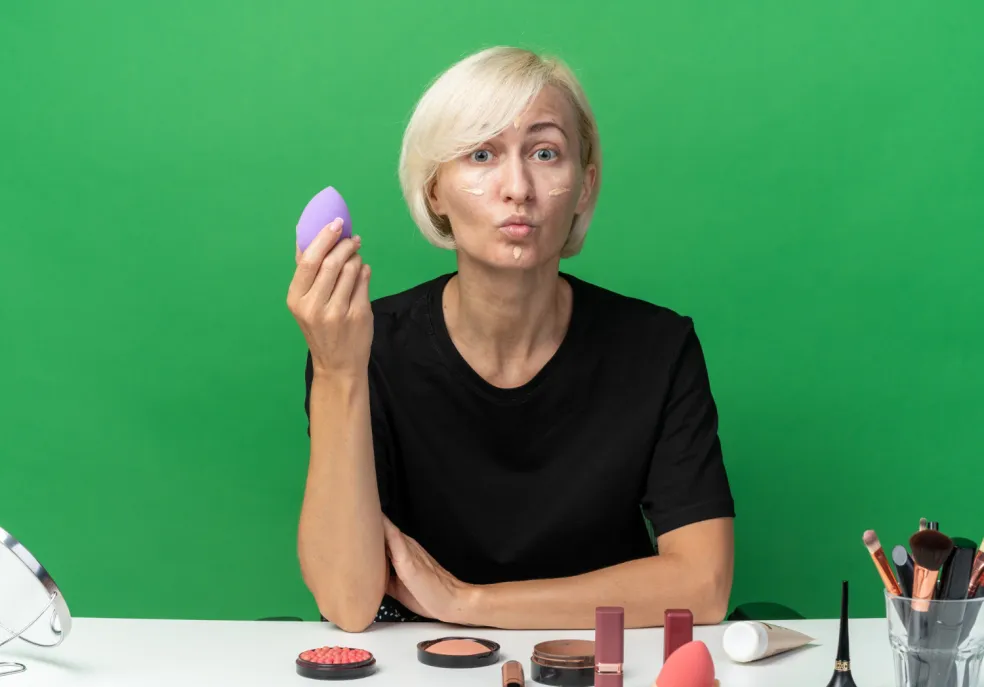 Prekvapená žena reagujúca na nepríjemný zápach zo zapáchajúcej hubky na make-up