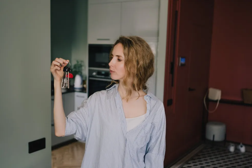 Žena drží zväzok kľúčov v ruke a premýšľa, ktorý z nich patrí k dverám – symbolika strateného kľúča v sne