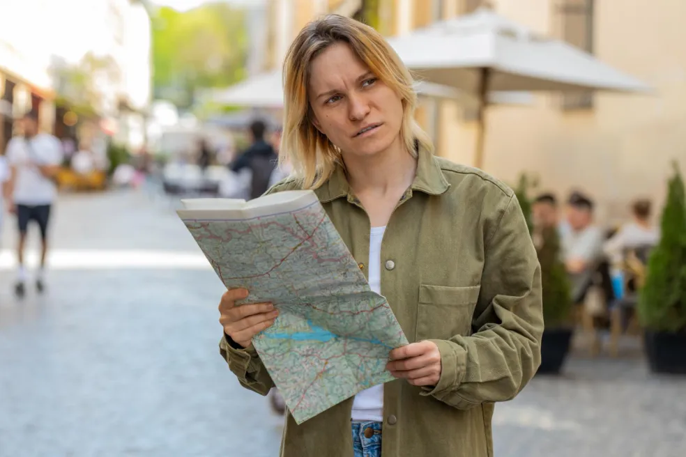 Žena zablúdená v meste hľadá podľa mapy správnu cestu – motív stratenia sa v sne