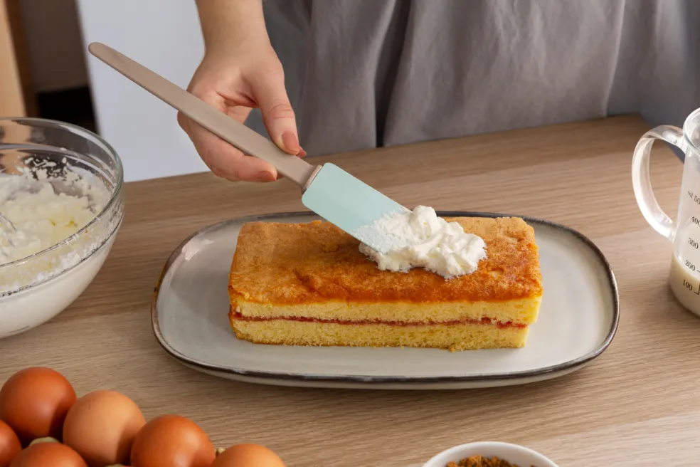 Nanášanie krémovej náplne na upečený koláč ako alternatíva cream cheese