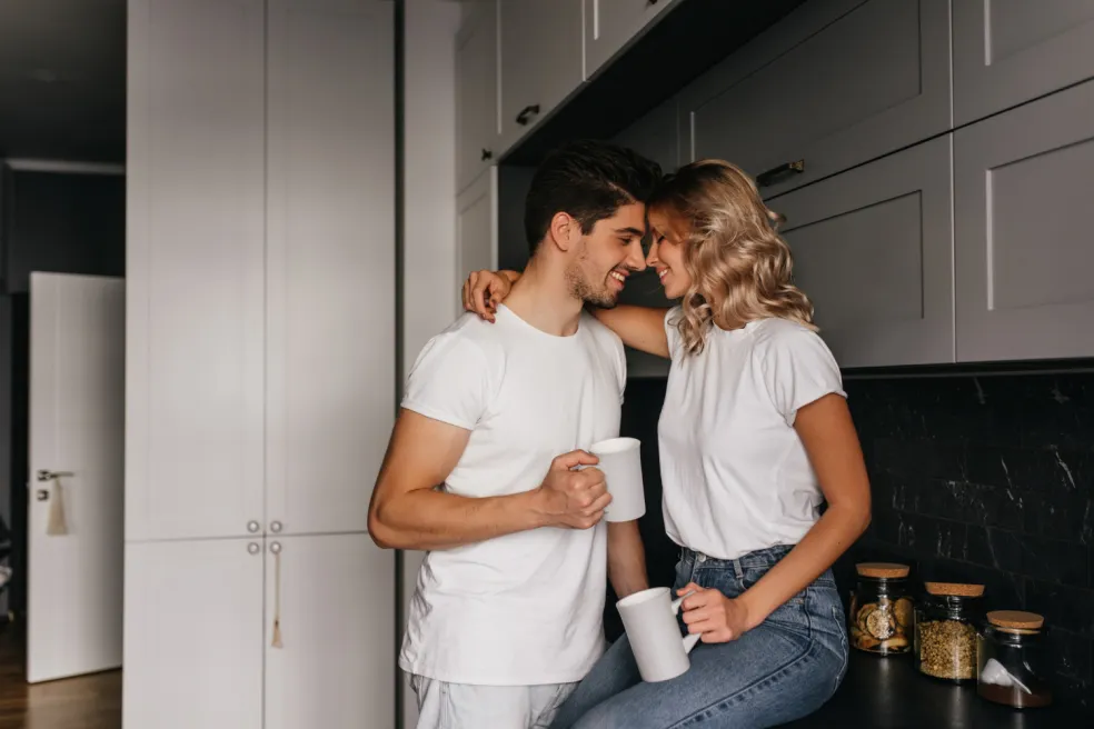 Zamilovaný pár si užíva nežnú spoločnú chvíľu pri káve v kuchyni