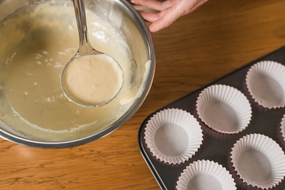 Plnenie papierových košíčkov cestom na hrnčekové jablkové muffiny