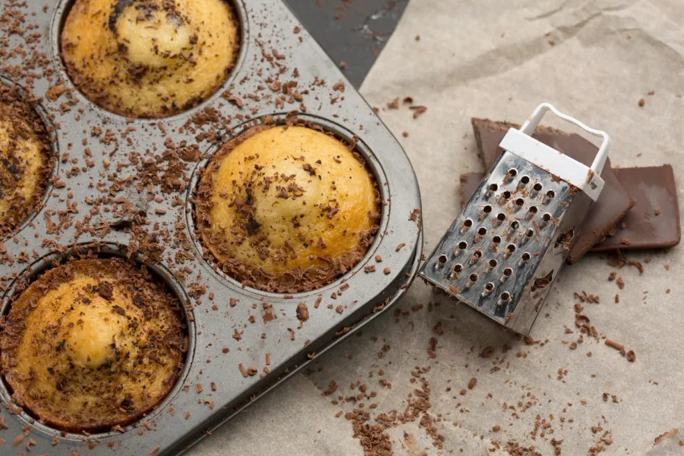 Upečené jablkové muffiny vo forme posypané strúhanou čokoládou