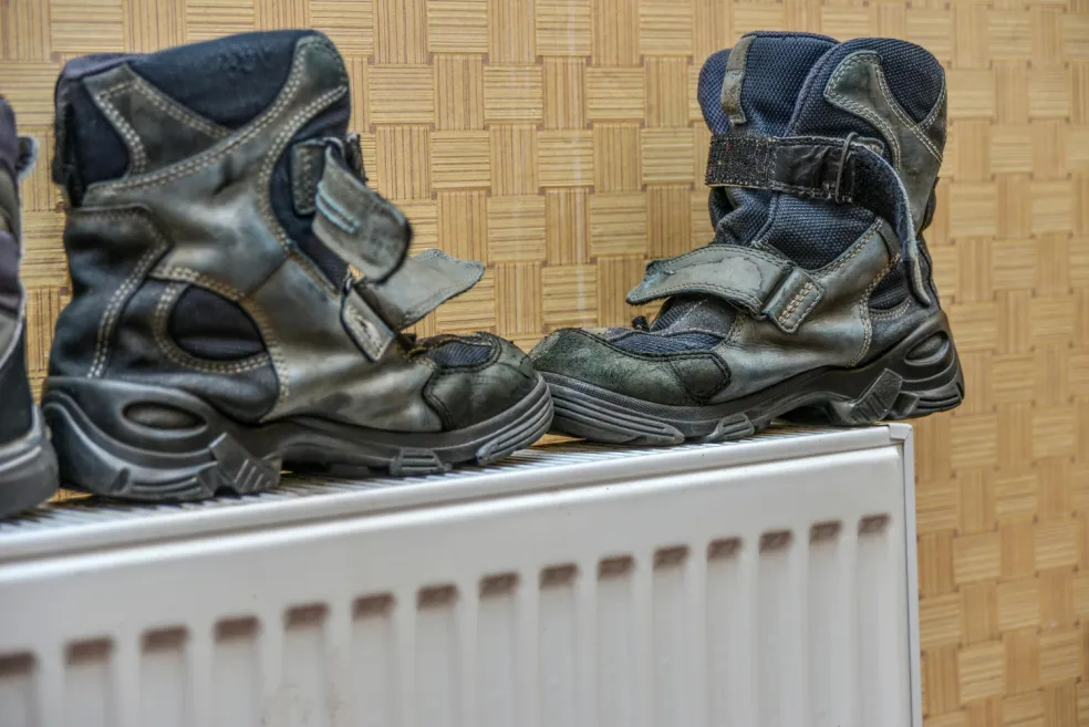 Mokré zimné topánky položené na radiátore – nevhodný spôsob sušenia obuvi, ktorý môže poškodiť materiál a lepené spoje